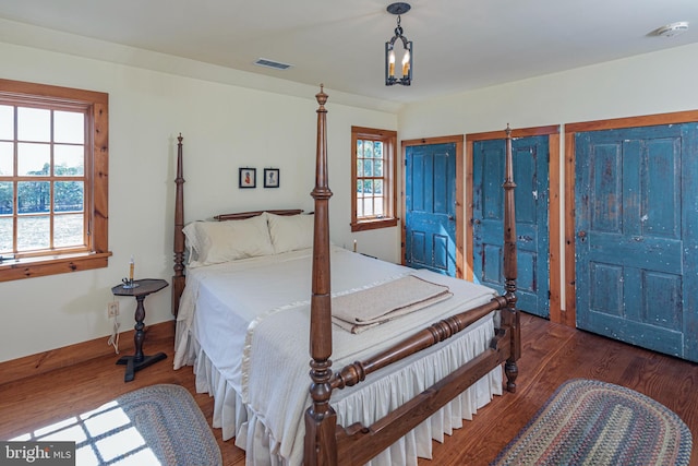 bedroom featuring multiple windows and dark hardwood / wood-style floors