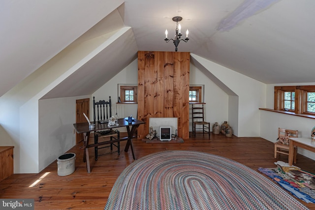 interior space with a chandelier, vaulted ceiling, and wood-type flooring