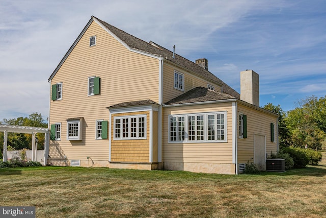 back of house featuring a pergola, a yard, and central AC unit