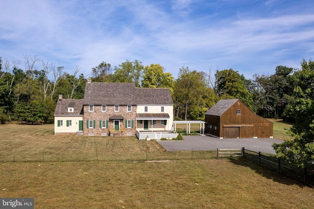 view of front of house with a front yard and an outdoor structure