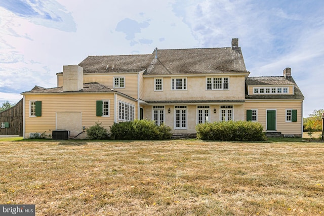 back of house with a yard and central air condition unit