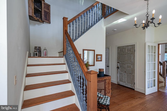 stairs featuring an inviting chandelier and hardwood / wood-style floors