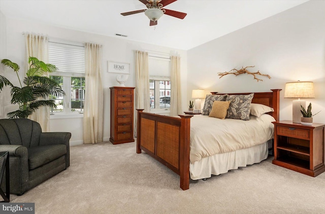 carpeted bedroom with multiple windows and ceiling fan