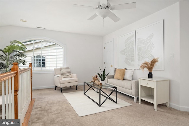 living area with ceiling fan, light colored carpet, and lofted ceiling