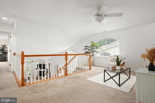 interior space with light carpet, ceiling fan, and vaulted ceiling