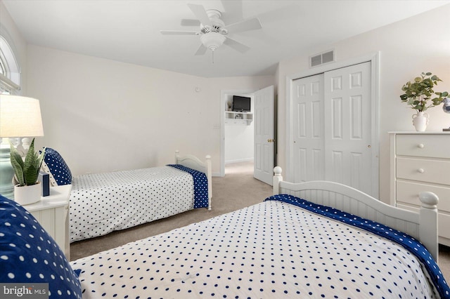 carpeted bedroom with ceiling fan and a closet