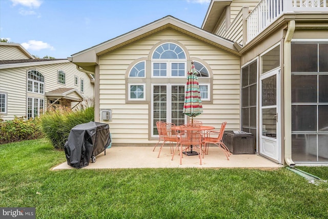 rear view of property with a lawn and a patio area