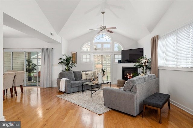 living room featuring lofted ceiling, ceiling fan, and wood-type flooring