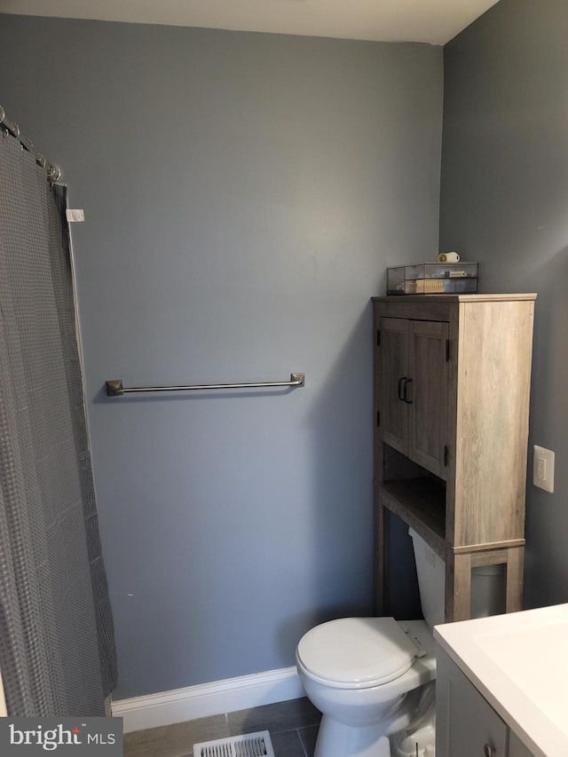 bathroom featuring tile patterned flooring, vanity, and toilet