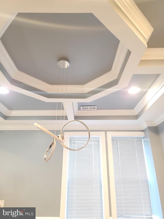 interior details with crown molding and a raised ceiling