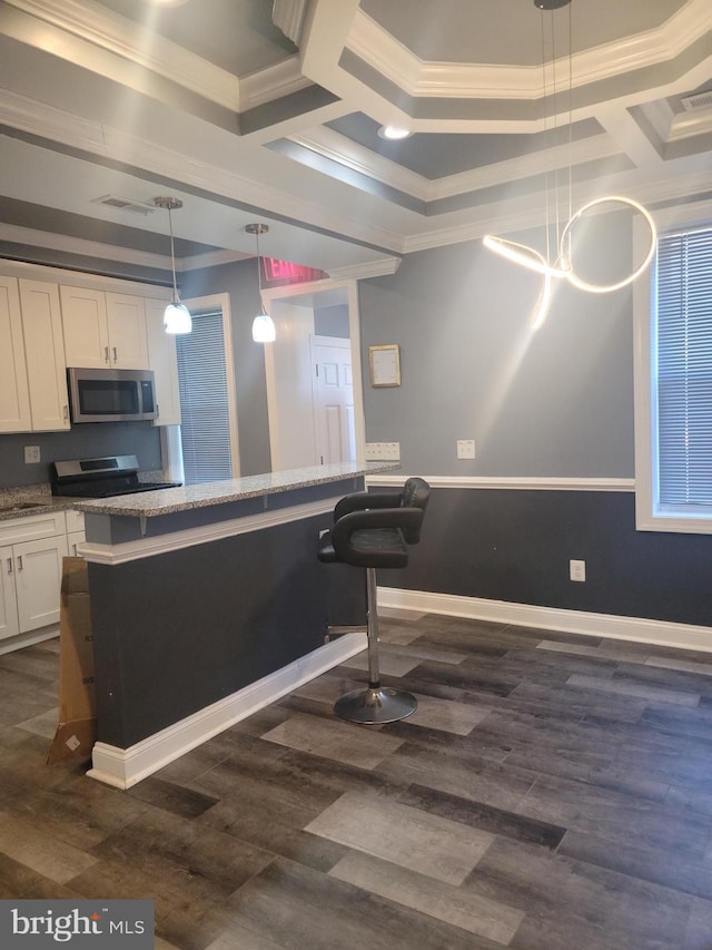 kitchen featuring a kitchen bar, dark hardwood / wood-style floors, pendant lighting, and white cabinets