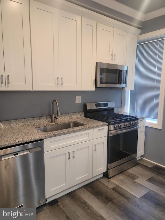 kitchen with sink, white cabinetry, stainless steel appliances, light stone countertops, and dark hardwood / wood-style flooring