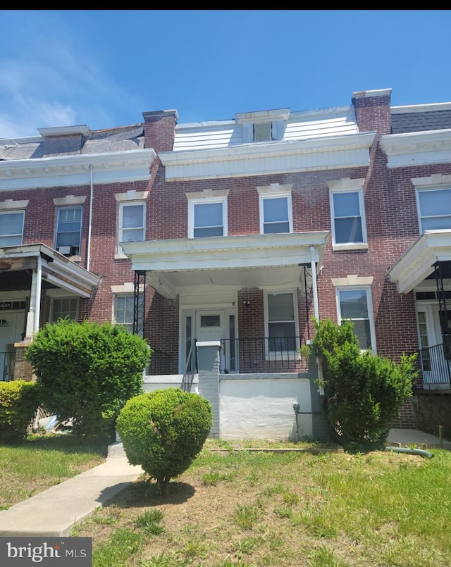 view of property with a front yard and covered porch