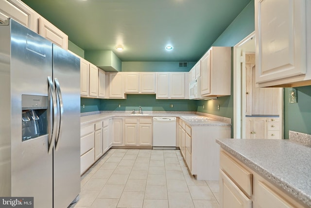 kitchen featuring white appliances, sink, and light tile patterned floors