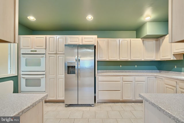 kitchen featuring stainless steel fridge and white double oven