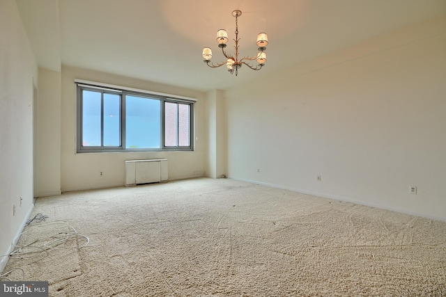 carpeted spare room with a notable chandelier