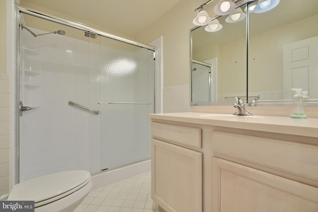 bathroom with tile patterned flooring, vanity, an enclosed shower, and toilet