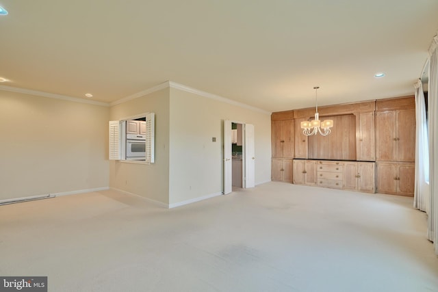 carpeted spare room featuring a notable chandelier and ornamental molding