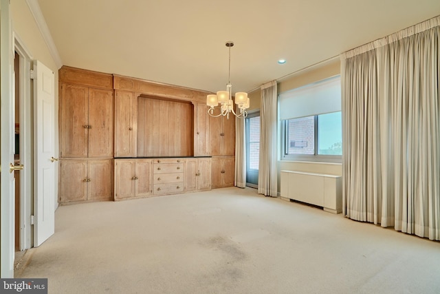 unfurnished dining area featuring light colored carpet, ornamental molding, and an inviting chandelier