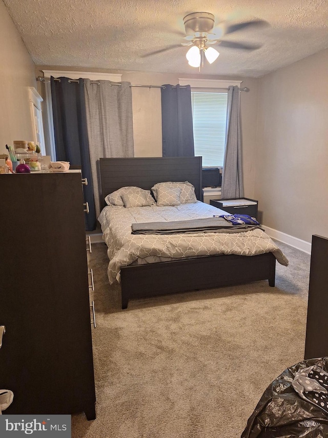 bedroom with a textured ceiling, ceiling fan, and carpet floors