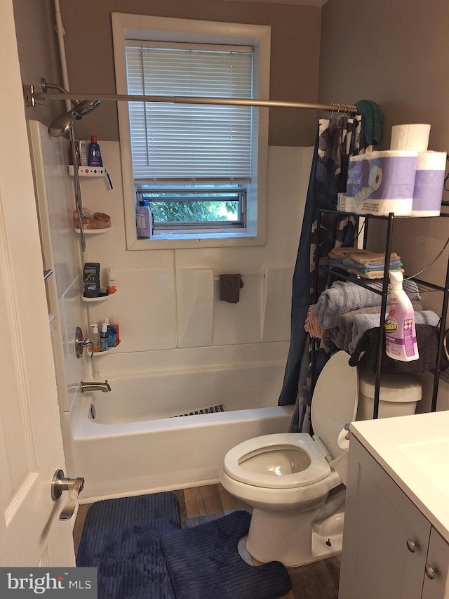 full bathroom featuring wood-type flooring, shower / bath combo, vanity, and toilet