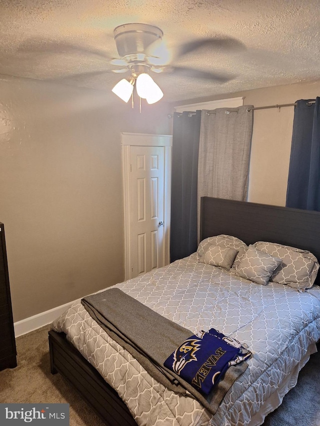 carpeted bedroom featuring ceiling fan and a textured ceiling