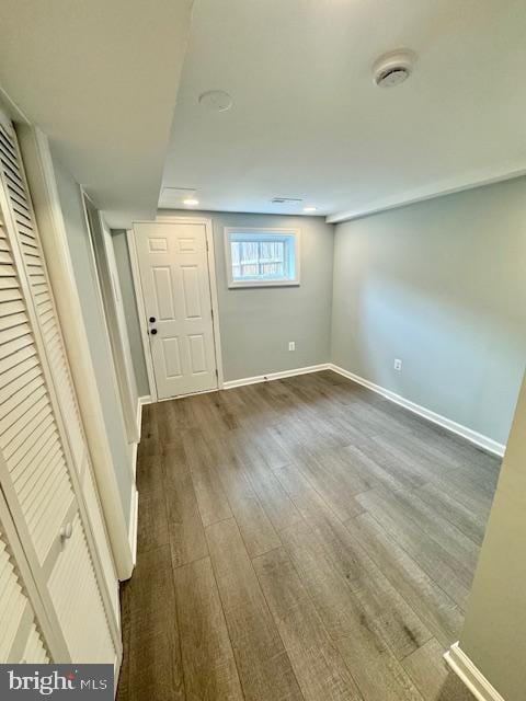 basement with dark hardwood / wood-style floors