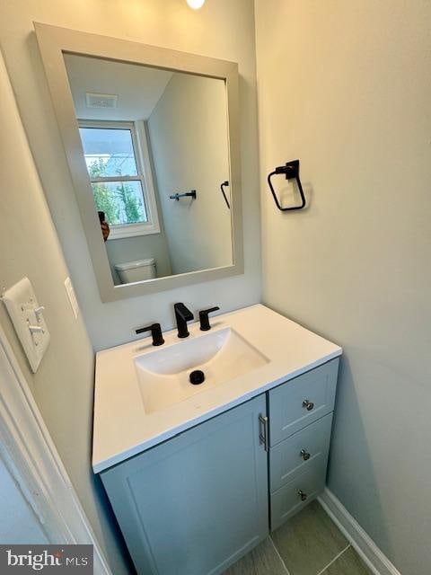 bathroom with vanity, toilet, and tile patterned flooring