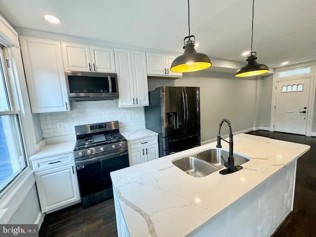 kitchen with appliances with stainless steel finishes, white cabinetry, and sink