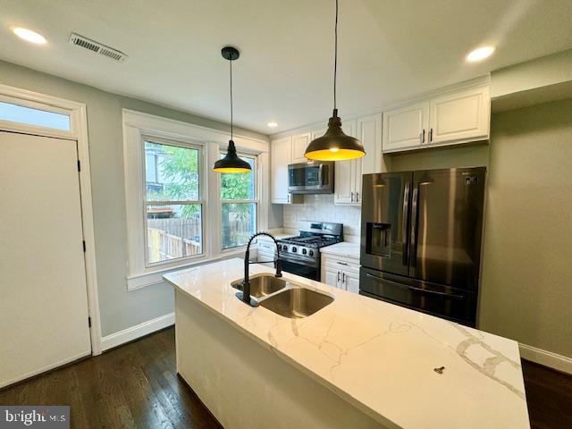 kitchen featuring light stone countertops, sink, appliances with stainless steel finishes, and white cabinetry