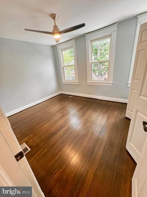 unfurnished room featuring ceiling fan and dark hardwood / wood-style flooring