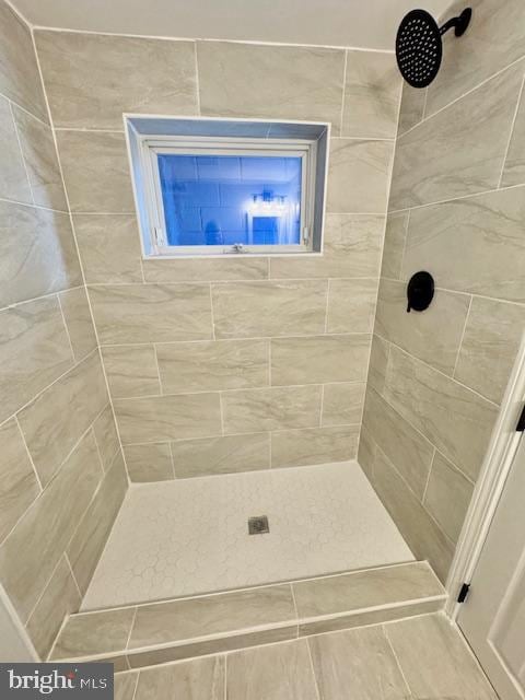 bathroom featuring a tile shower and tile patterned flooring