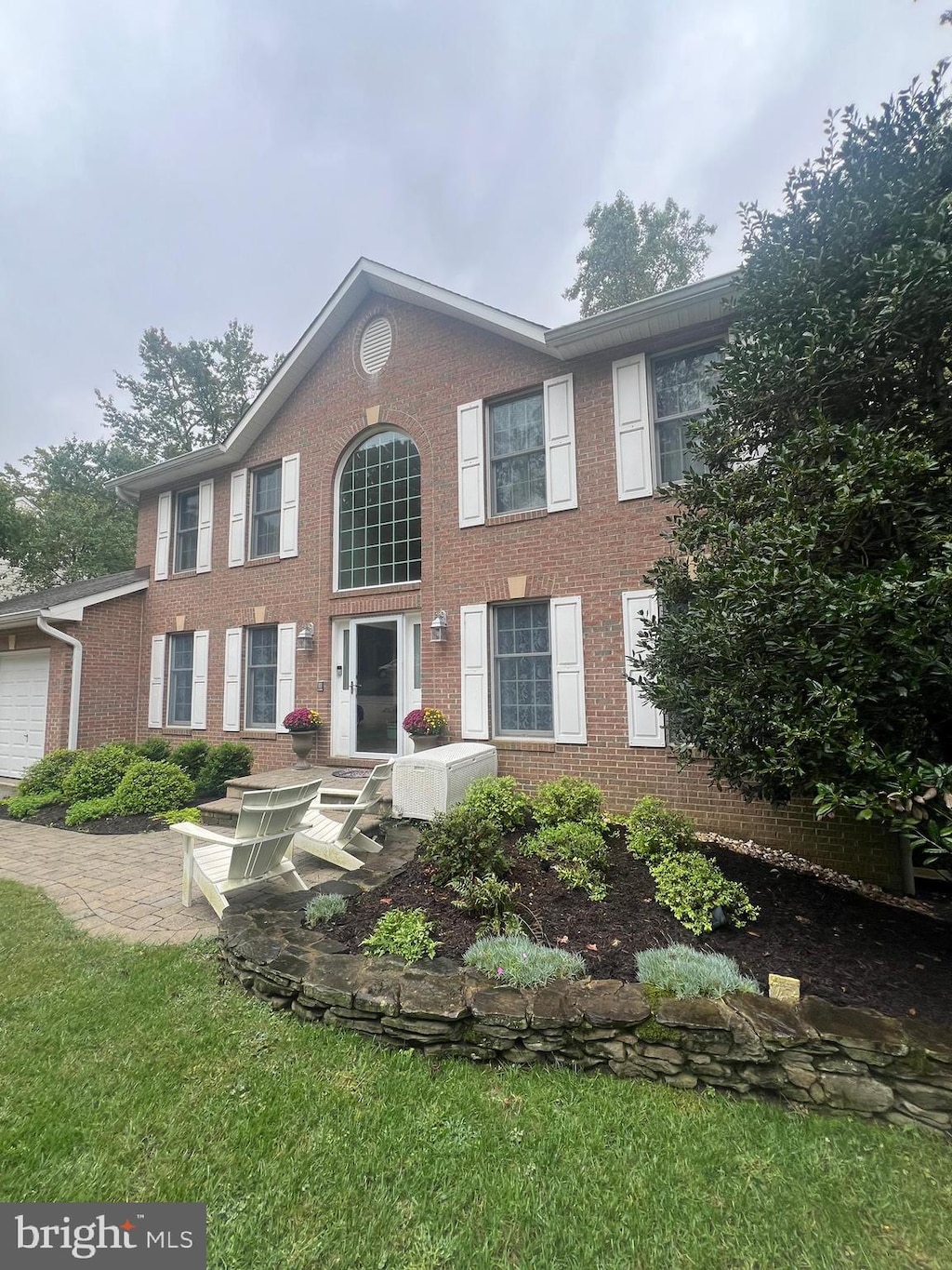 colonial home with a garage and a front lawn