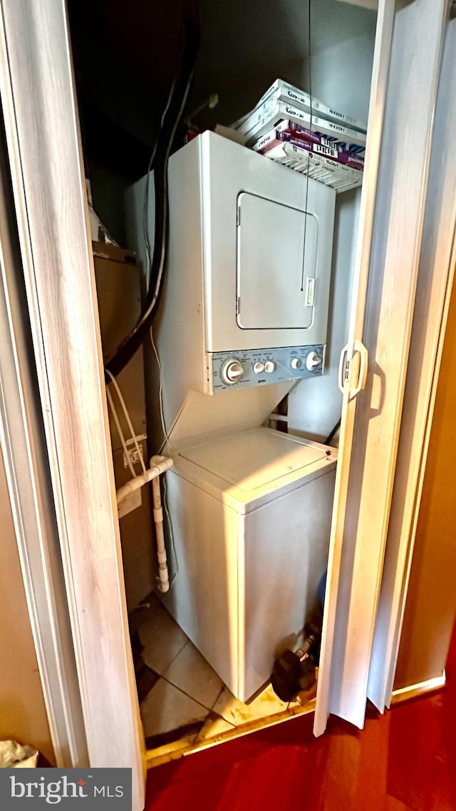 clothes washing area featuring stacked washer / dryer