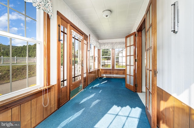 sunroom / solarium featuring french doors and a baseboard heating unit