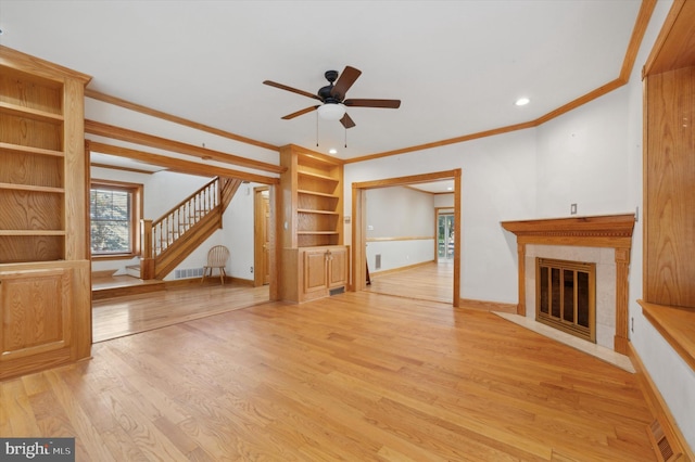 unfurnished living room with ceiling fan, light wood-type flooring, and crown molding