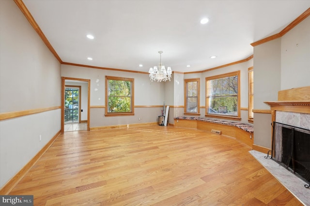 living room with light wood-type flooring, a healthy amount of sunlight, and crown molding