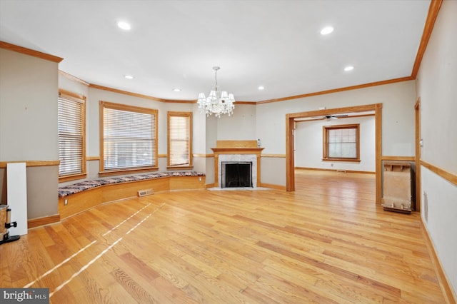 unfurnished living room featuring ornamental molding, light hardwood / wood-style flooring, and a notable chandelier