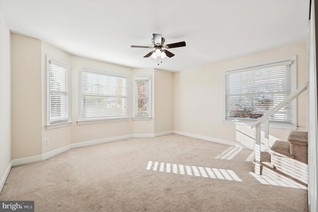 carpeted spare room featuring ceiling fan