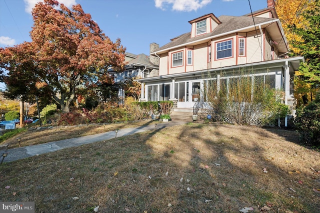 view of front of house featuring a front lawn and a sunroom