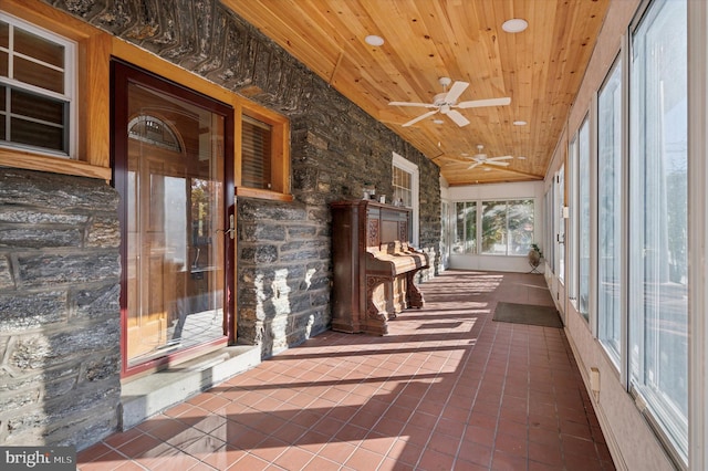 unfurnished sunroom featuring wood ceiling, vaulted ceiling, and ceiling fan