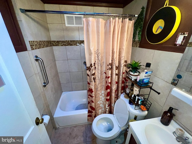 full bathroom with toilet, tile patterned flooring, shower / tub combo with curtain, tile walls, and vanity