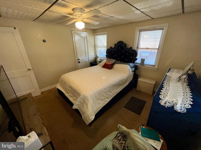 bedroom with a drop ceiling and ceiling fan