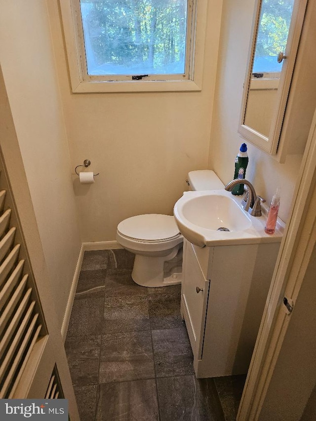 bathroom featuring vanity, plenty of natural light, and toilet