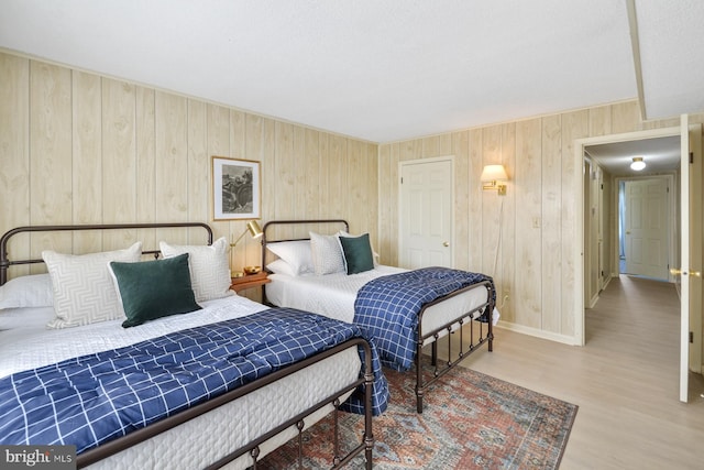 bedroom with wood-type flooring and wooden walls