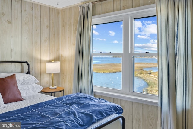 bedroom with wood walls and a water view