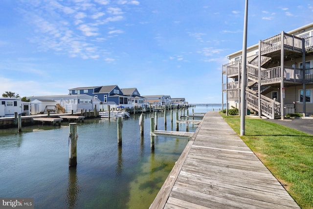 view of dock featuring a water view and a yard