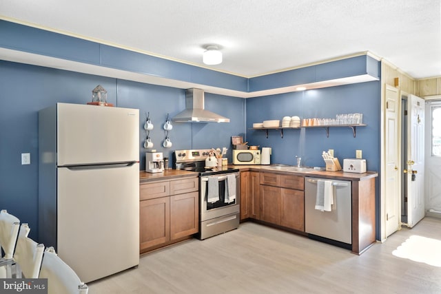 kitchen featuring light hardwood / wood-style floors, stainless steel appliances, a textured ceiling, sink, and wall chimney range hood