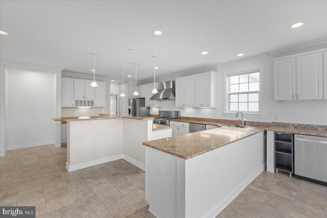 kitchen featuring pendant lighting, a center island, white cabinets, wall chimney exhaust hood, and stainless steel appliances