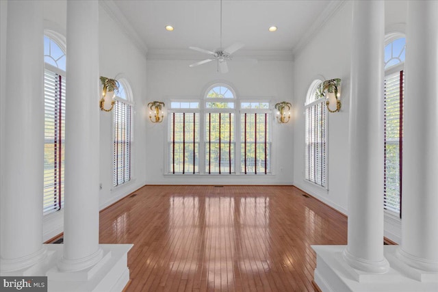 interior space featuring light wood-type flooring, plenty of natural light, and ornate columns